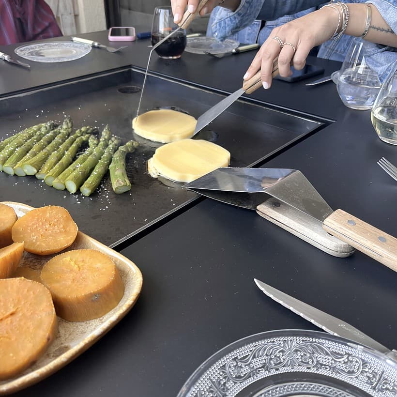 Personas cocinando y compartiendo alrededor de una mesa Volcano, escena 2